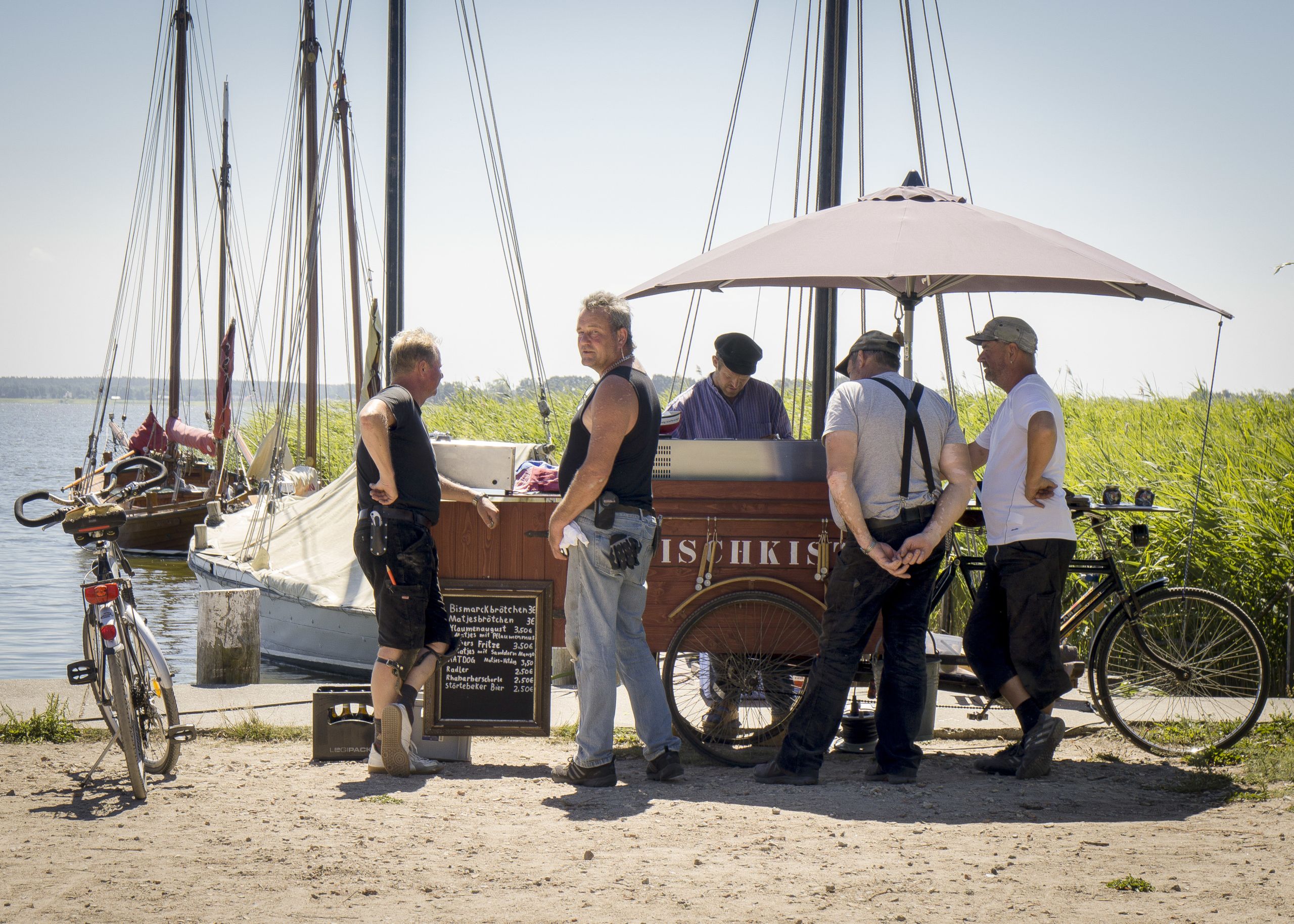 Gruppo di persone vicino a una barca tradizionale, costa Baltica